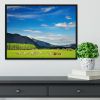 Mountain landscape with grazing cows and sky Framed Print